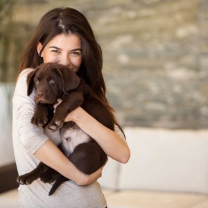 happy woman hugging a puppy