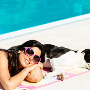 woman and her dog getting a tan by the pool