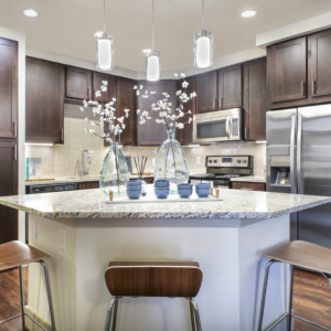 Kitchen at Origin featuring granite, stainless steel appliances and pendant lighting