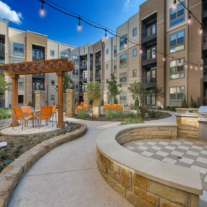 Courtyard at Origin featuring multiple private seating areas with patio furniture and grilling area