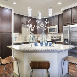 Kitchen at Origin featuring granite, stainless steel appliances and pendant lighting