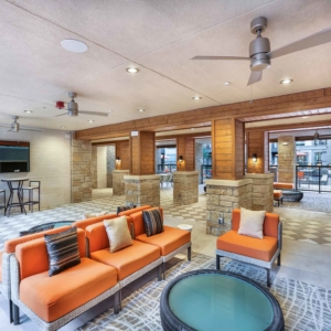 indoor-outdoor lounge area at Origin at frisco bridges featuring lounge furniture and flat screen tvs